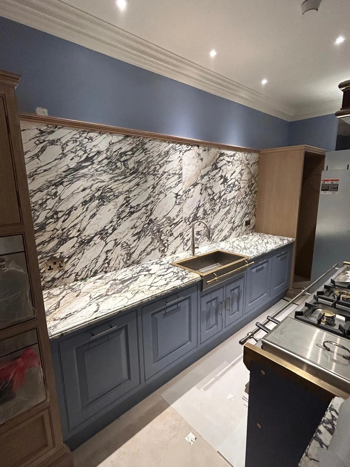 Blue in-frame kitchen with marble worktops: The finished run