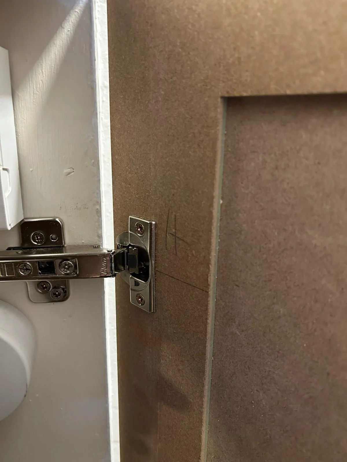 A concealed hinge on one of the angled under-stairs doors