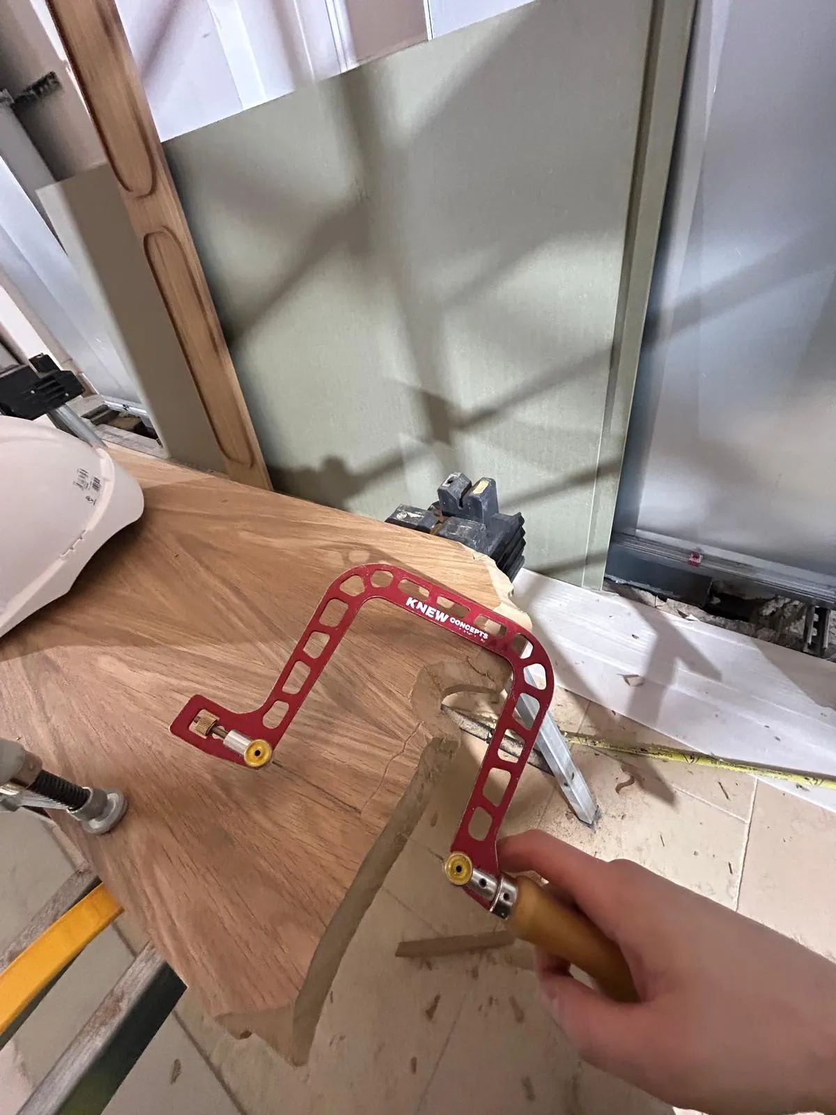 Cutting a traced profile into an oak panel by hand with a coping saw