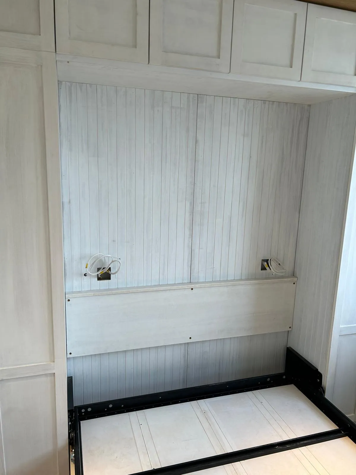 The panelled headboard between the wardrobes