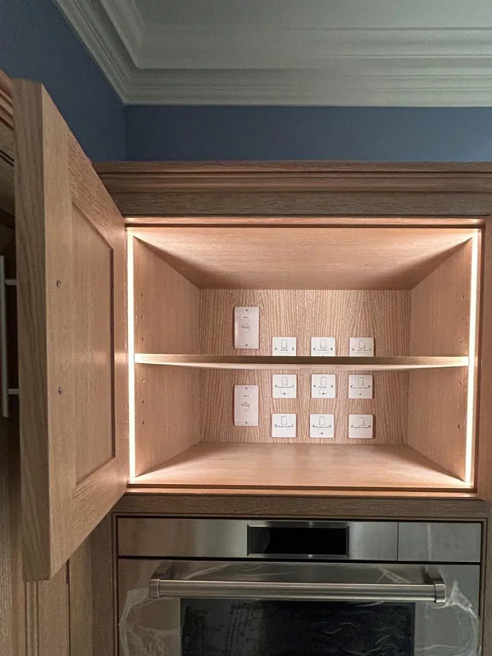 Lit oak shelving inside a tall kitchen unit